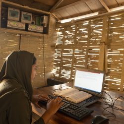 A village student practices typing using a laptop at the boat library run by Shidhulai Swanirvar Sangstha, at Borda Nagar Uttor Para, Chatmohor, Pabna. Photo: Abir Abdullah/Shidhulai Swanirvar Sangstha